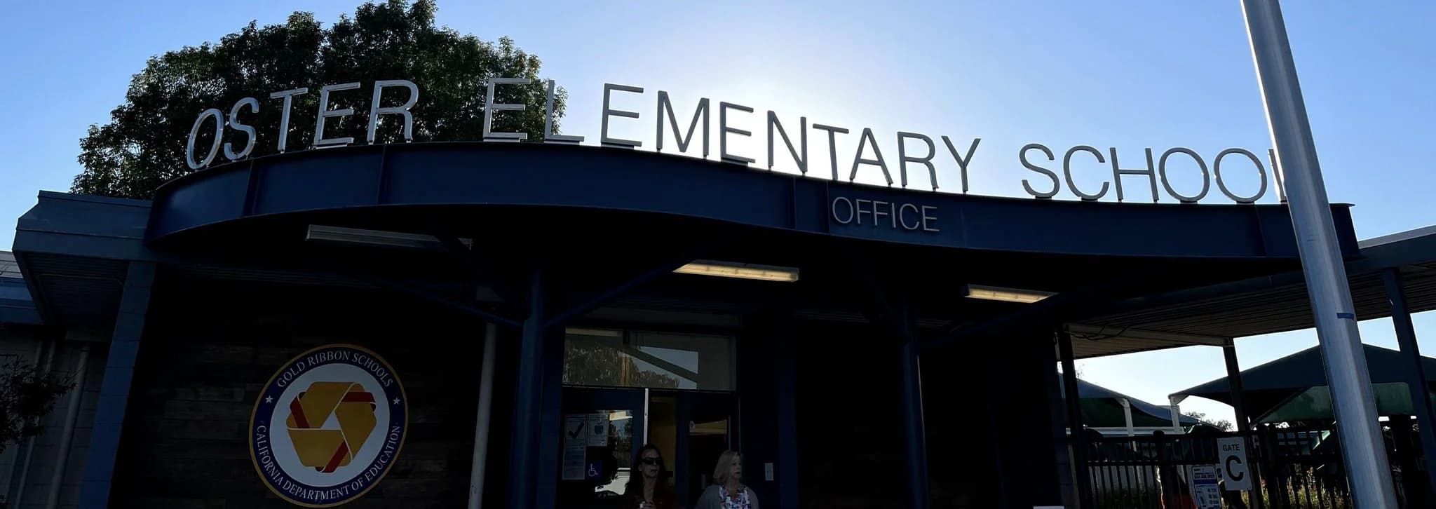 Oster Elementary School office entrance with school name on the blue overhang